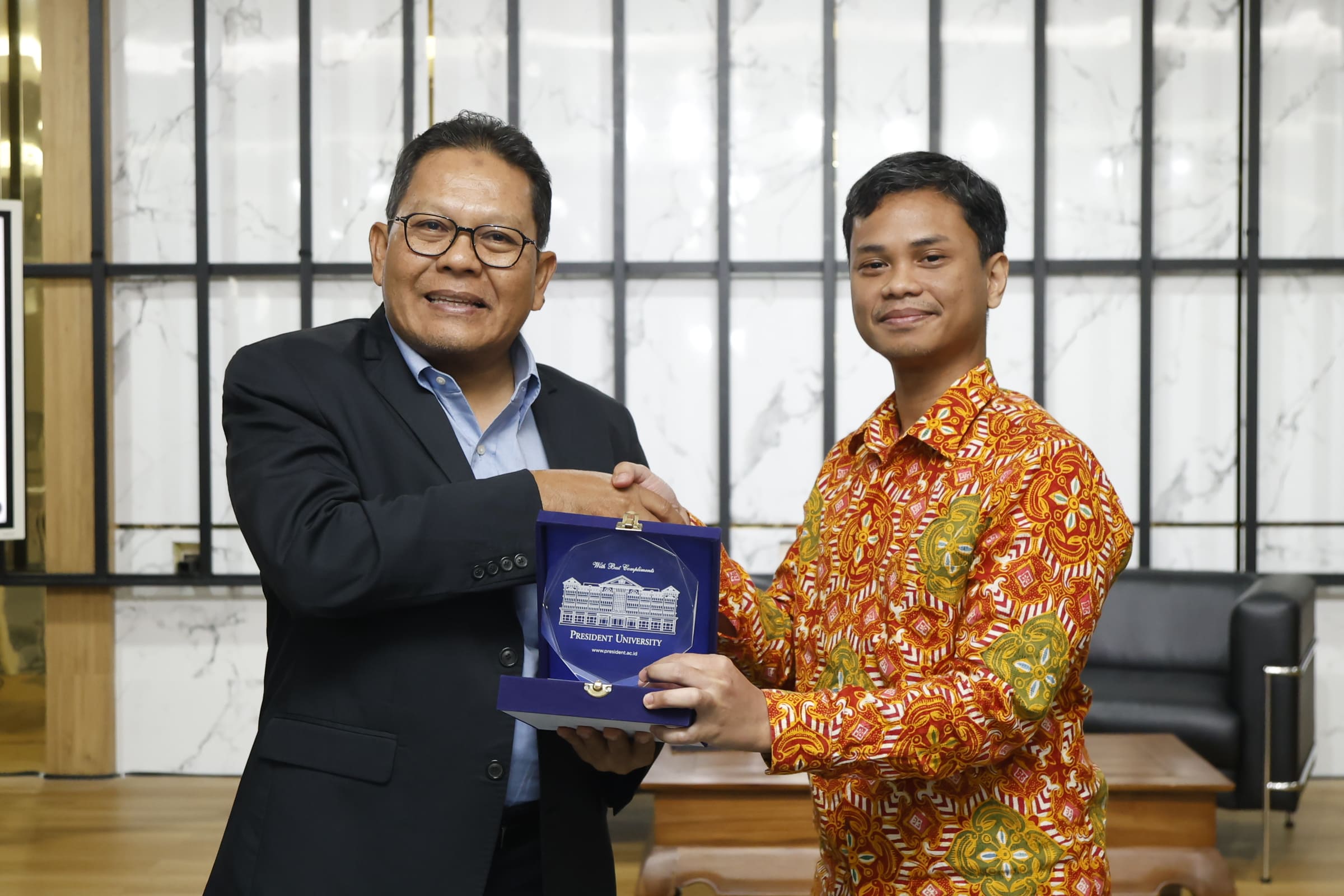Prof. Ari Purbayanto dan perwakilan President University menyerahkan cendera mata